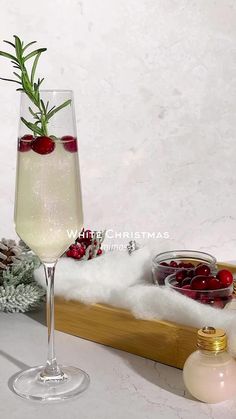 a glass filled with liquid sitting on top of a wooden tray next to christmas decorations