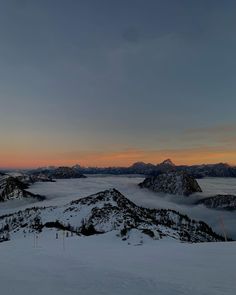 the sun is setting over some mountains covered in snow