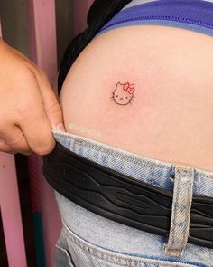 a person with a hello kitty tattoo on their stomach is holding onto the side of her belly