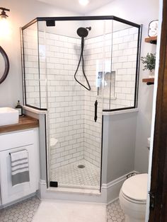 a white toilet sitting next to a walk in shower