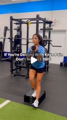 a woman is doing squats in the gym while holding a dumbble weight machine