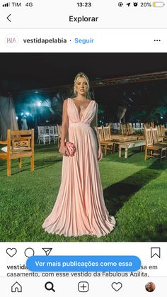 a woman in a pink dress is standing on the grass