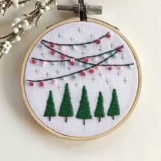 a cross stitch christmas ornament with trees