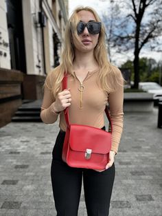 This personalized leather shoulder bag is a stylish and practical choice for everyday use. Crafted in a striking red, this crossbody women's bag combines functionality with minimalist design. It's perfect for carrying daily essentials while adding a pop of color to any outfit. As a unique gift for your sister or a special woman in your life, this bag is both thoughtful and personal. Its high-quality leather and customizable options make it a standout piece that she'll cherish for years to come. Minimalist Flap Bag With Adjustable Strap, Red Flap Bag With Adjustable Strap For Office, Red Crossbody Flap Bag For Office, Trendy Leather Shoulder Bag For Gift, Trendy Leather Shoulder Bag As Gift, Trendy Flap Bag As A Gift, Trendy Flap Bag Gift, Trendy Flap Bag As Gift, Everyday Red Saddle Bag With Detachable Strap