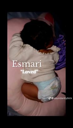 a baby laying on top of a pink pillow with the words esmari loved