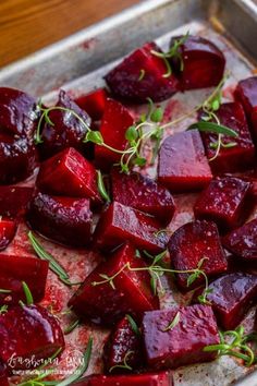 roasted beets on a baking sheet ready to be cooked in the oven with herbs