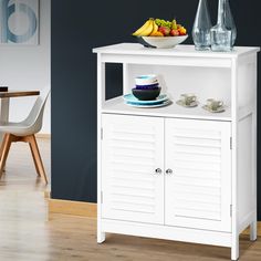 a white cabinet with some fruit on top of it and two cups in front of it