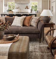 a living room filled with furniture next to a kitchen