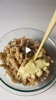 a glass bowl filled with pasta and sauce