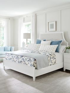 a bedroom with white furniture and blue accents