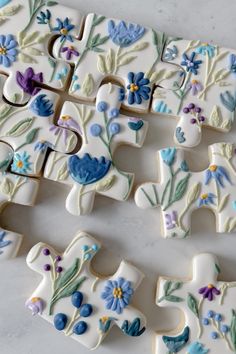 decorated cookies are arranged in the shape of letters and flowers on a white countertop