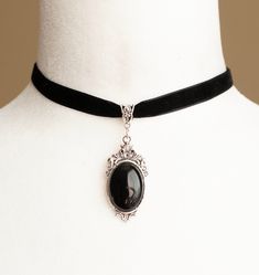 Enhance your elegance with this exquisite Victorian-inspired choker, crafted from luxurious black velvet ribbon and adorned with an antique silver filigree pendant featuring a striking Black Onyx stone centerpiece. Key Features: -Material: Made from soft black velvet ribbon, this choker exudes Victorian charm and sophistication. The antique silver filigree pendant houses a beautiful Black Onyx stone for a touch of mystique. -Dimensions: The choker measures 12 inches (30.5cm) in length and 0.4 in Black Choker With Pendant, Emo Wedding, Victorian Vampire, Black Velvet Ribbon, Pirate Outfit, Moon Fairy, Ribbon Choker, Black Velvet Choker, Formal Accessories