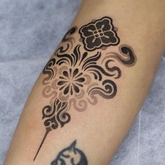 a close up of a person's arm with a tattoo design on the arm