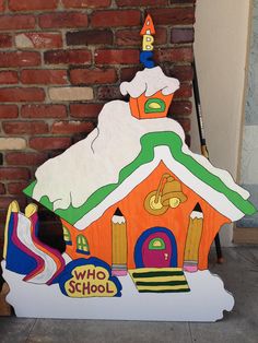 a cardboard house with a snowman on top and the words who's school?