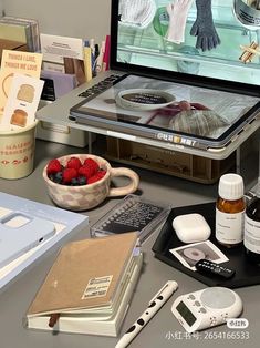 a desk with various items on it including an electronic device, books and other things