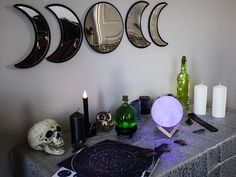 a table topped with plates and candles next to a wall mounted moon phases on the wall