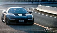 a black sports car driving down the road