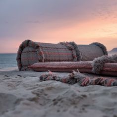 pillows and blankets on the beach at sunset