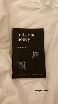 the book milk and honey by rupi kaur is laying on a white sheet