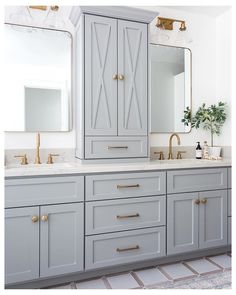 a bathroom with two sinks, mirrors and cabinets in grey colors on the countertop