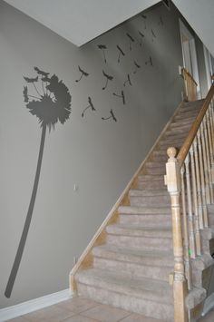 a staircase leading up to a wall with a dandelion stencil on it