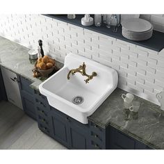 a white sink sitting on top of a kitchen counter next to blue cabinets and drawers