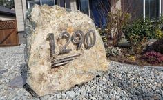 a large rock with the number 2090 written on it in front of a house