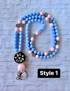 a blue and pink beaded necklace hanging on a brick wall with the name style 1