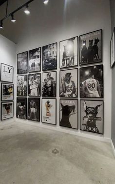 an art gallery with many black and white pictures on the wall, including men's shirts