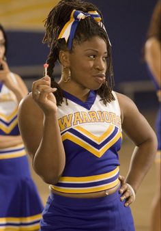 the cheerleaders are dressed in blue and yellow uniforms, one holding a cell phone to her ear