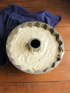 a bundt cake sitting on top of a wooden table next to a blue napkin