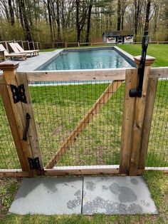 a fenced in pool with a wooden gate