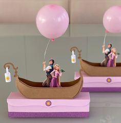 two figurines are floating in a boat with balloons