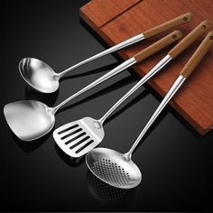 four stainless steel utensils with wooden handles