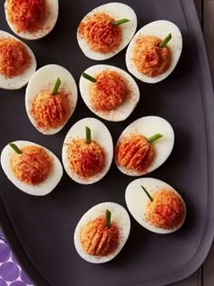 deviled eggs with tomato sauce on a tray