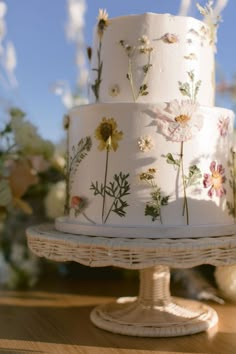 a three layer white cake with flowers on it