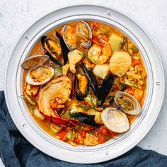 a white bowl filled with seafood and clams