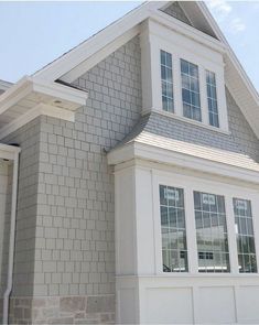 a white house with gray shingles and windows