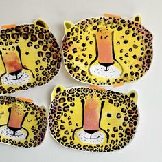 four hand painted plates with leopard faces on them