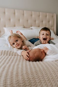 two children laying on a bed with their mouths open