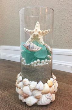 a glass vase filled with sea shells and starfish