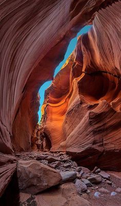 the inside of a large canyon with rocks and water on the ground in front of it