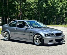 a silver car parked in front of some trees