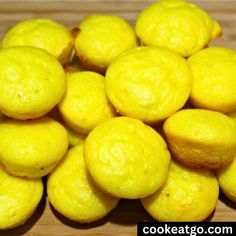 a pile of lemons sitting on top of a wooden table next to each other