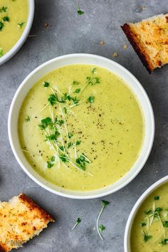 three bowls of soup with toast on the side