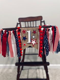 an american flag banner is hung on a chair with pom poms around it