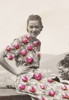 an old photo of a woman in a dress with pink flowers on the skirt and her hands on her hips