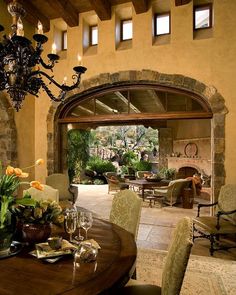 a dining room table with chairs and a chandelier hanging from it's ceiling