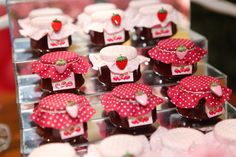 there are many small desserts on display in the glass case with red polka dots