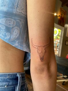 a close up of a person with a tattoo on their arm and cow's head